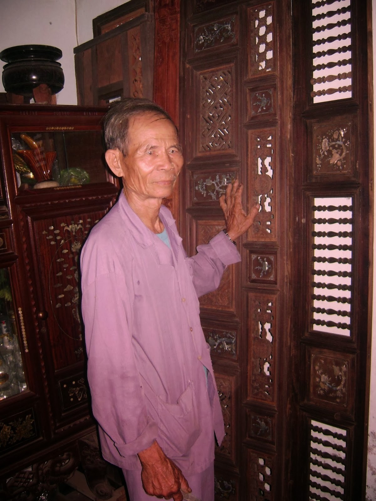 Nghệ nhân Nguyễn Màn bên bộ cửa được chạm khắc tinh xảo 